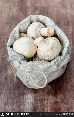 Fresh button mushrooms on wooden background, selective focus