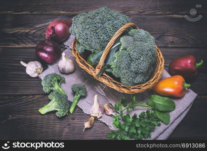 fresh cabbage broccoli in a basket on a brown wooden table, top view, vintage toning