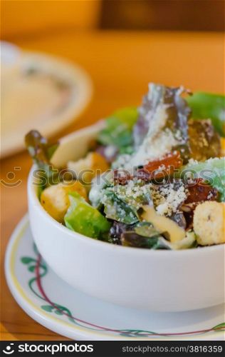 fresh caesar salad . fresh caesar salad on bowl with parmesan cheese