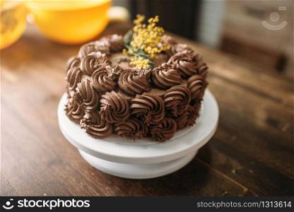 Fresh cake with chocolate biscuit cream, culinary masterpiece, closeup view. Sweet dessert on wooden background