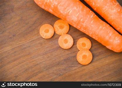 fresh carrot and Carrot slices on wooden background top view