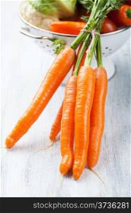 fresh carrot and vegetables in colander