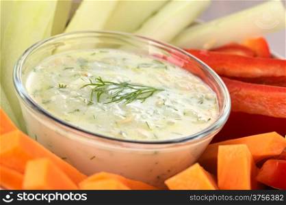 Fresh carrots, cucumbers and pepper with tzatziki dip (Selective Focus, Focus on the dill on the tzatziki)