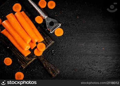 Fresh carrots on a cutting board. On a black background. High quality photo. Fresh carrots on a cutting board.