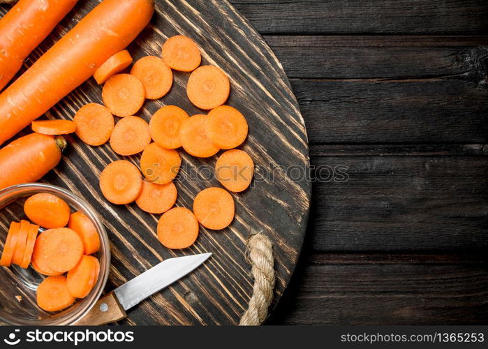 Fresh carrots on a cutting Board with a knife. On wooden background. Fresh carrots on a cutting Board with a knife.