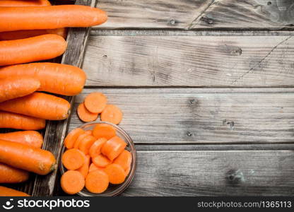 Fresh carrots on a wooden tray. On wooden background. Fresh carrots on a wooden tray.