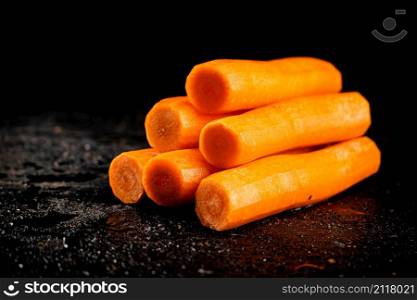 Fresh carrots on the table. On a black background. High quality photo. Fresh carrots on the table.