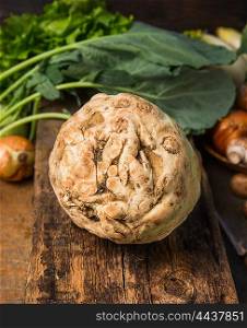 Fresh celeriac with knife on old rustic wooden table, close up