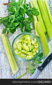 fresh celery in glass bowl and on a table
