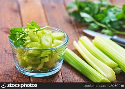 fresh celery in glass bowl and on a table