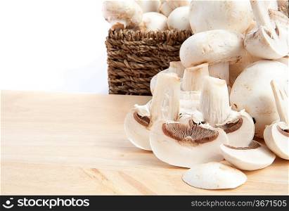 Fresh champignon mushrooms in rustic woven basket isolated on white background