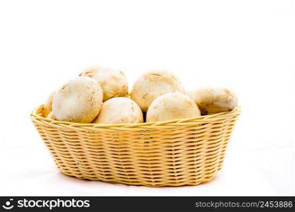 Fresh champignons, champignon mushrooms in wicker basket isolated