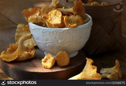 Fresh chanterelle mushrooms in a bowl on the dark rustic background. Close up .. Fresh chanterelle mushrooms in a bowl on the dark rustic background. Close up