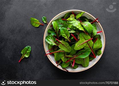 Fresh chard leaves on black background top view