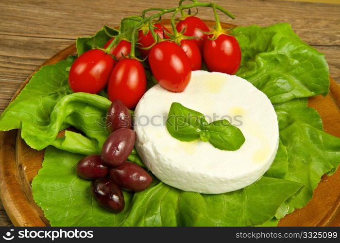 fresh cheese with salad, tomatoes and black olives