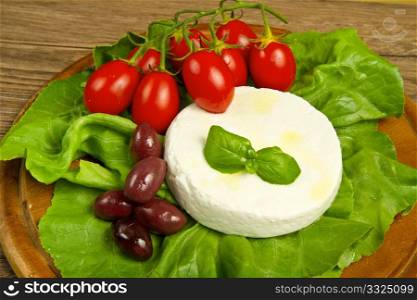 fresh cheese with salad, tomatoes and black olives