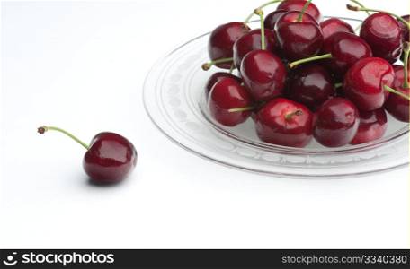 Fresh Cherries On A Glass Plate, With A Single Cherry To The Side, On A White Background