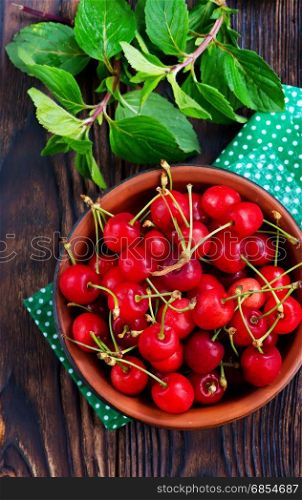 fresh cherry in bowl and on a table