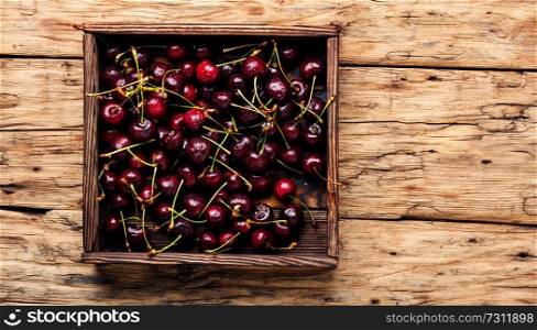 Fresh cherry in box on wooden blue background.Sweet cherries.Cherry.. Cherries on wooden table