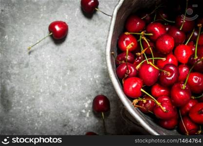 Fresh cherry in the old pot. On the stone table.. Fresh cherry in the old pot.