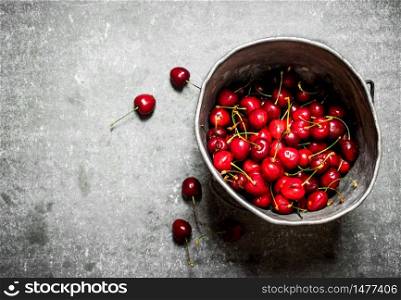 Fresh cherry in the old pot. On the stone table.. Fresh cherry in the old pot.