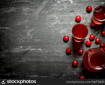 Fresh cherry juice. On a black wooden background.. Fresh cherry juice.