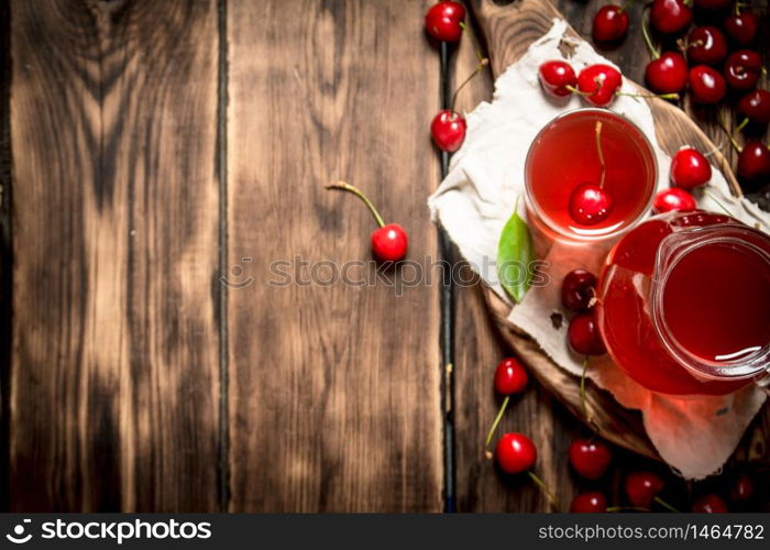 Fresh cherry juice . On a wooden background.. Fresh cherry juice .On wooden background.