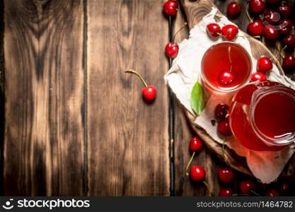 Fresh cherry juice . On a wooden background.. Fresh cherry juice .On wooden background.