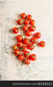 Fresh cherry tomatoes from garden on light shabby rustic background, top view