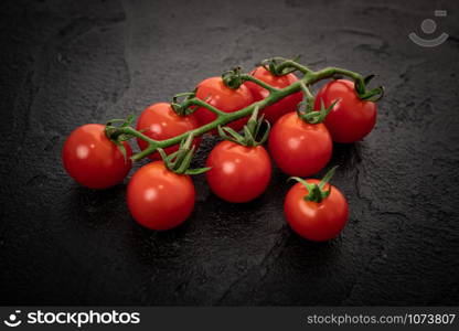Fresh cherry tomatoes on a black background