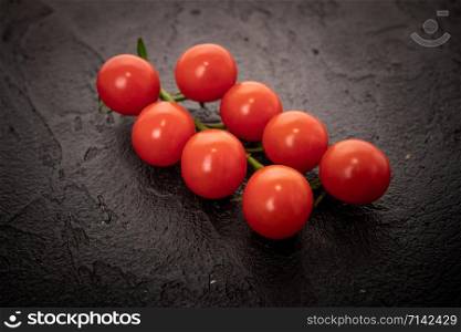 Fresh cherry tomatoes on a black background