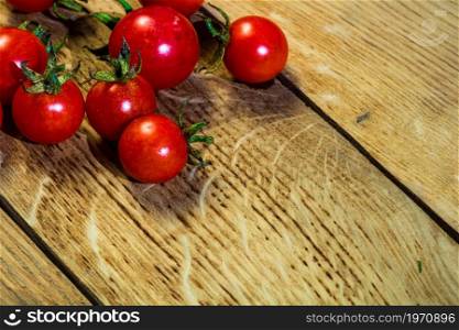 Fresh cherry tomatoes on rustic wooden background