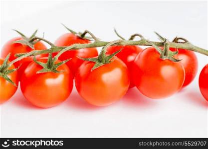 Fresh cherry tomatoes on stem isolated on white