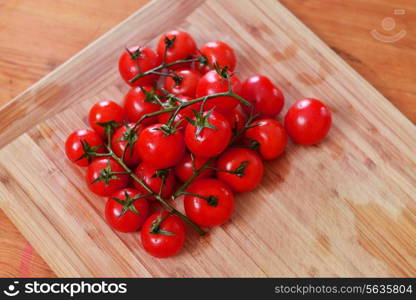 Fresh cherry tomatoes on wooden background