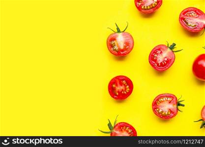 Fresh cherry tomatoes, whole and half cut isolated on yellow background. Copy space