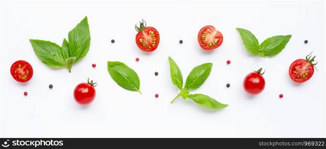 Fresh cherry tomatoes with basil leaves and different type of peppercorns on white background. Top view