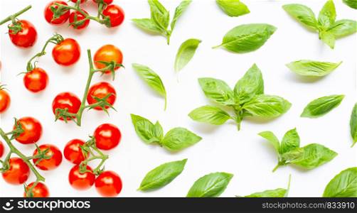 Fresh cherry tomatoes with basil leaves on white background. Top view