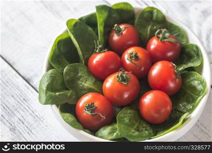Fresh cherry tomatoes with spinach leaves