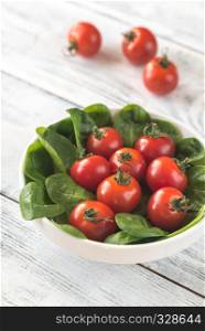 Fresh cherry tomatoes with spinach leaves