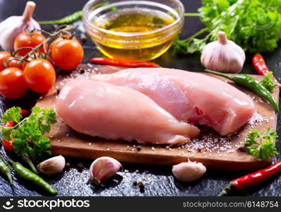 fresh chicken fillet with vegetables on dark board