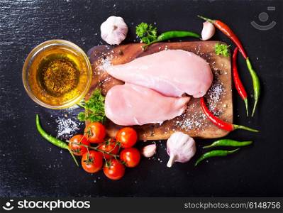 fresh chicken fillet with vegetables on dark board