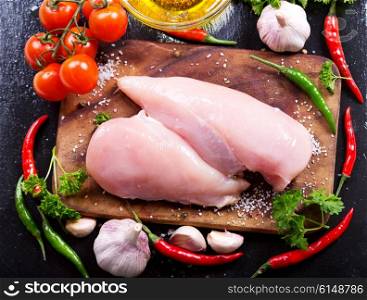 fresh chicken fillet with vegetables on dark board