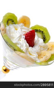 fresh chopped strawberries, kiwi and banana with whipped cream in glasswares