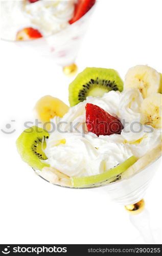 fresh chopped strawberries, kiwi and banana with whipped cream in glasswares