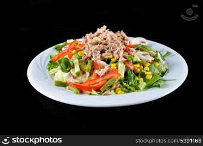 fresh chopped tuna salad with spinach on black background