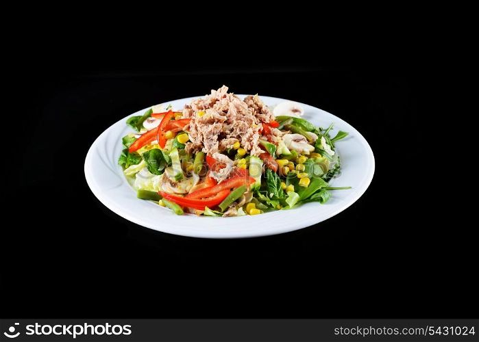 fresh chopped tuna salad with spinach on black background