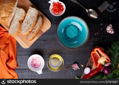fresh ciabatta bread  with blue bowl and ingredients served at dark wooden table. meditarranean cuisine. flat lay 