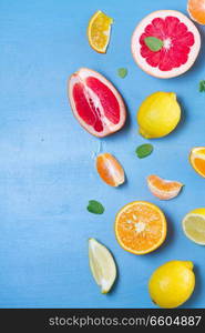 fresh citrus food border on blue background - assorted citrus fruits with mint leaves. citrus pattern on blue