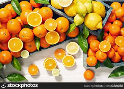 Fresh citrus fruits on wooden table. Orange fruits, lemons, tangerines, limes. Healty food, vitamin C