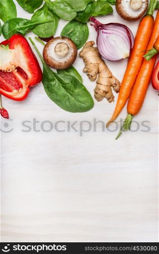 Fresh clean garden vegetables for tasty cooking on white wooden background, top view. Place for text. Vegan and Healthy food concept.